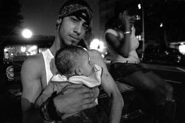 21 year old gang member Pedro holds his newborn.