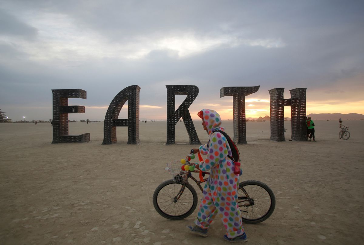 A participant walks past an art installation as approximately 70,000 people from all over the world gather for the 30th annual Burning Man arts and music festival in the Black Rock Desert of Nevada, U.S. August 30, 2016. REUTERS/Jim Urquhart FOR USE WITH BURNING MAN RELATED REPORTING ONLY. FOR EDITORIAL USE ONLY. NOT FOR SALE FOR MARKETING OR ADVERTISING CAMPAIGNS. NO THIRD PARTY SALES. NOT FOR USE BY REUTERS THIRD PARTY DISTRIBUTORS - RTX2NN7P